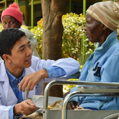 A high school student speaks to a patient on Projects Abroad's medical internship in Kenya An intern working with a patient on our medical internship for teenagers in Kenya